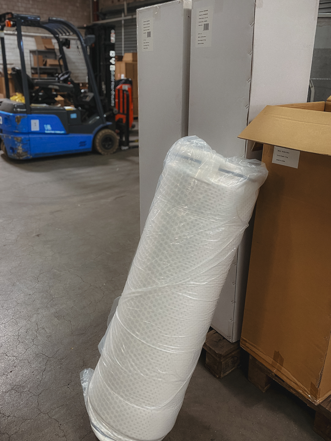 gerollte und verpackte Matratze im Lager