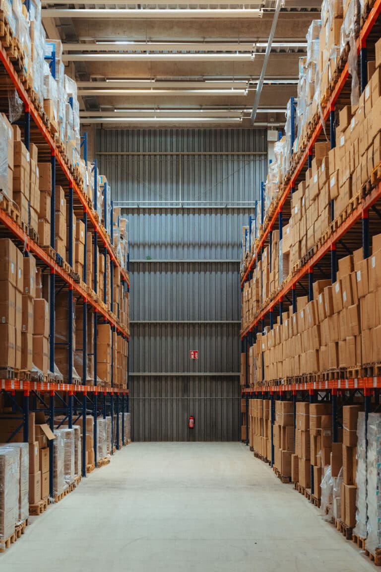 Symmetrische Hochregale in einer modernen, weitläufigen Logistikhalle.